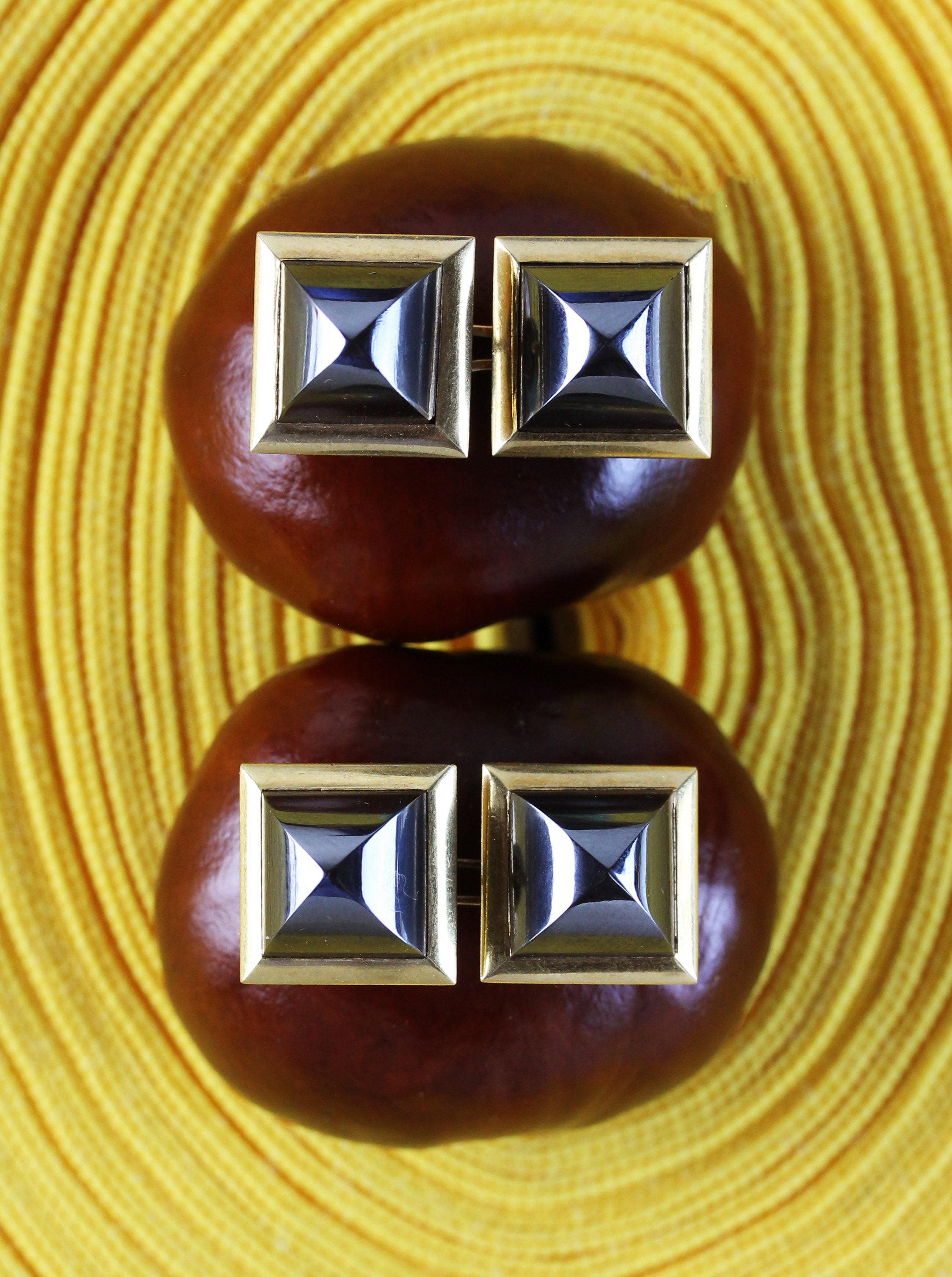Gold cufflinks with triangular pyramid cut hematites